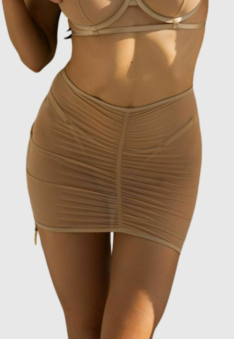 Nude siateczkowa spódnica mini o marszczonym wykończeniu, dopasowanym kroju i boku z zapięciem na zamek. Zawiera subtelne przeszycia i gładkie wykończenie.
