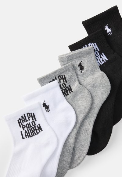 Cuatro pares de calcetines tobilleros en blanco, gris y negro; material de mezcla de algodón con textura acanalada y logo bordado.