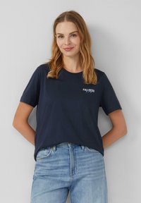 T-shirt en coton bleu marine à manches courtes, col rond, avec un design de texte "FULLNESS" en blanc sur la poitrine. Coupe décontractée.
