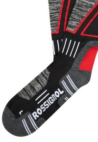 Calze nere e grigie con accenti rossi. Presentano un motivo testurizzato e righe bianche. Nome del marchio "ROSSIGNOL" in evidenza.