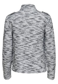 Szary i czarny melanżowy sweter z długimi rękawami i wysokim kołnierzem, widziany od tyłu.