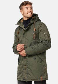 Olivgrüne Parka-Jacke mit einem weichen, strukturierten Futter und einer verstellbaren Kapuze. Verfügt über Reißverschluss- und Druckknopftaschen sowie Akzente aus braunem Leder.