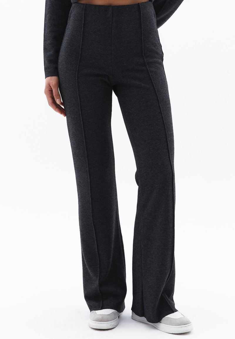 Donkergrijze flared broek van een zachte, gestructureerde stof met verticale stikdetails. Heeft een hoge tailleband en een relaxed fit.