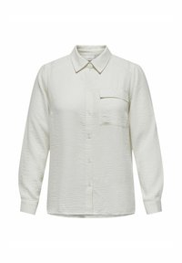 Cămașă albă, texturată, cu guler și mâneci lungi. Are un singur buzunar pe piept și închidere cu nasturi în față.