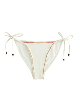 Białe bikini z dolną częścią ze sznureczkami po bokach, ozdobione brązowym i wielobarwnym wzorem haftu krzyżykowego wzdłuż krawędzi.