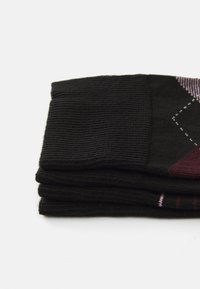 Chaussettes noires avec une texture côtelée, pliées soigneusement. Présentent un design géométrique en marron et rose. Tissu doux, longueur mi-mollet.