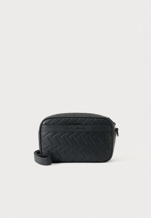 Sort rektangulær crossbody taske med præget zigzag mønster og "Armani Exchange" logo på fronten, mod en hvid baggrund.