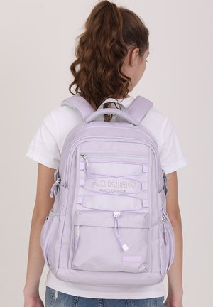 Lilac backpack with multiple compartments, mesh accents, adjustable padded straps, and a front zip pocket. Smooth fabric texture.