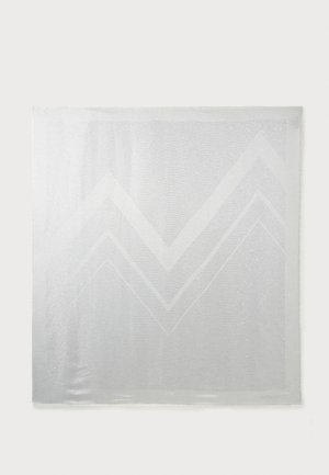 Tissu carré blanc avec un motif chevron subtil et brillant et un bord encadré sur un fond uni.