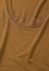 Débardeur en coton marron avec un col arrondi, texture lisse et coutures renforcées autour des bords. Design simple et polyvalent.