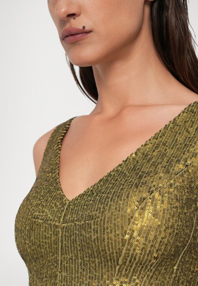 Auksinė blizgučių suknelė su giliu V formos iškirpimu ir tekstūruota raštu, turinti vertikalias linijas ir prigludusią siluetą. Lygus audinys.