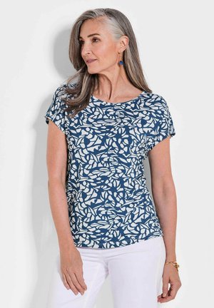 T-shirt navy à manches courtes avec un motif de feuilles blanches, col rond et tissu doux, associé à un pantalon blanc.