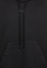 Svart bomullshoodie med frontlomme, justerbare snorer og en glatt tekstur. Har metallagler på snorene.