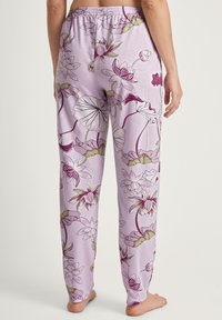 Lila pyjamabroek van zacht stof, met een bloemenpatroon met roze en groene accenten. Elastische tailleband voor comfort.