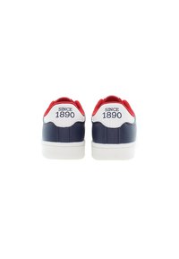 Námořnické modré kožené tenisky s bílým akcentem na patě a červeným límcem. Text "OD ROKU 1890" vytištěný na zadní straně. Bílá gumová podrážka.