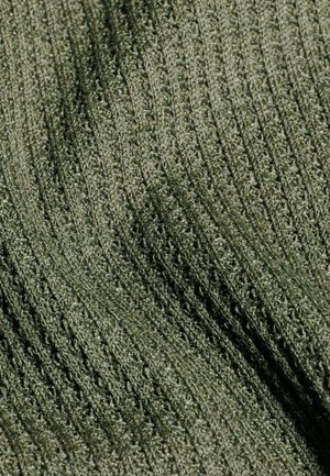 Close-up van textuurrijke olijfgroene gebreide stof met geribbelde, golvende patronen en een licht glanzend oppervlak.