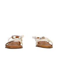 Witte sandalen met metalen accenten, platte zolen en een gespenontwerp. De binnenzool is bruin, met een gladde textuur en minimale details.