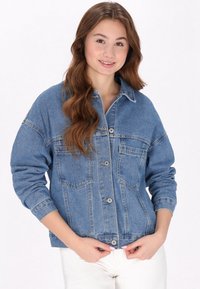 Jeansjacka i blått, med långa ärmar, stora bröstfickor, knäppning med knappar och en avslappnad passform. Texturerad tyg med en något bleknad utseende.