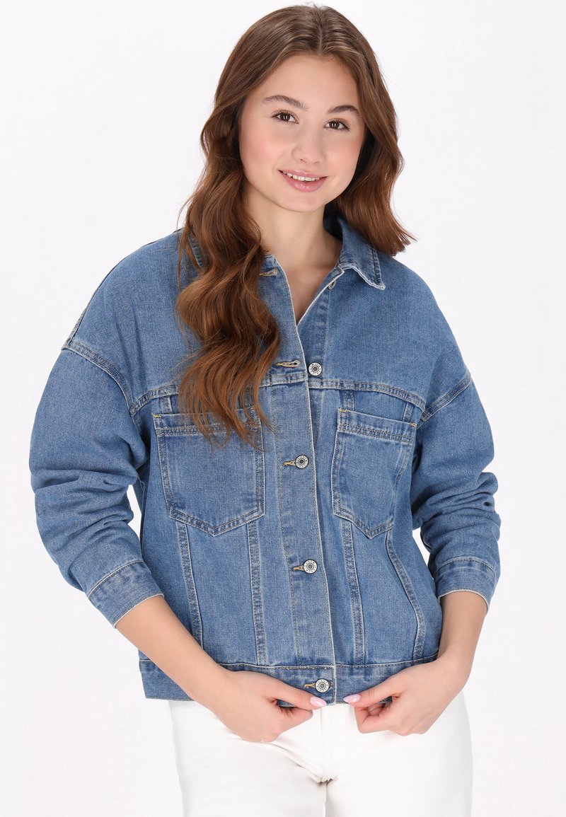 Jeansjacka i blått, med långa ärmar, stora bröstfickor, knäppning med knappar och en avslappnad passform. Texturerad tyg med en något bleknad utseende.