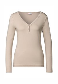 Camicia beige da donna a maniche lunghe con scollatura a V e due bottoni, realizzata in tessuto morbido, etichetta "Street One" sul colletto.