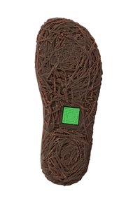 Suela de goma marrón con un patrón texturizado similar a paja. Un logo de rana verde está centrado en un parche rectangular negro.