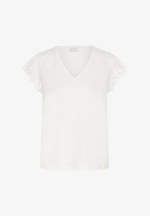 Blouse blanche à col en V avec manches courtes en dentelle ornées de motifs floraux, présentée sur un fond uni.