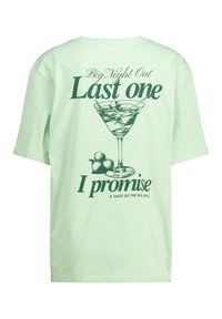 Mint green T-shirt featuring a graphic of a martini glass with olives and text: "Big Night Out Last one I promise A Taste of the Big Apple."
