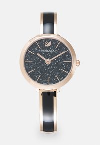 Swarovski Armbanduhr mit schwarzem strukturiertem Zifferblatt, Gehäuse aus roségold und schwarzem Emaille-Armband. Verfügt über minimalistische Stundenmarker und ein Markenlogo.