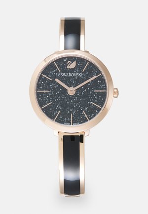 Swarovski wristwatch with a black textured dial, rose gold case, and black enamel bangle. Features minimalist hour markers and a brand logo.