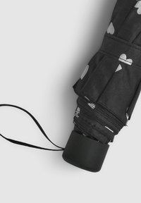 Czarny z�łożony parasol z gładką czarną rączką, na czaszy wzór białych serc, zabezpieczony czarnym paskiem.