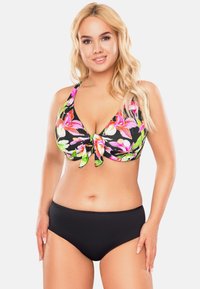 Fekete bikini virágmintás toppal, amely élénk rózsaszín és zöld virágokkal díszített, köz�épen megkötött rész található, és egyszínű fekete alsókkal.