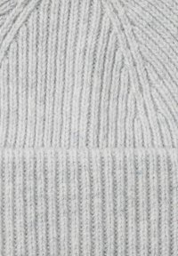 Tela de lana de punto gris claro con textura acanalada vertical y fibras suaves visibles.