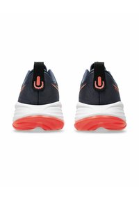 Baskets de sport marine avec semelles blanches et orange ; présentent un dessus texturé et une languette. La vue arrière met en évidence le design et le contraste de couleur.