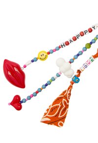 Kolorowy naszyjnik z zawieszkami w kształcie czerwonych ust i serc, koralikami w formie uśmiechniętych buziek oraz liter, a także pomarańczowym frędzlem z białymi wzorami.