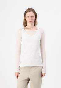 Langermet hvit topp med bred hals og lagdelte stropper. Laget av gjennomsiktig stoff, har den en avslappet passform og en glatt, lett tekstur.