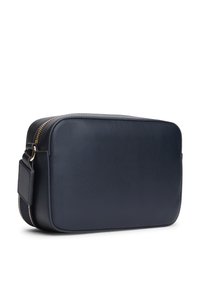 Tumesinist nahast õlakott ristimiskujuga, ristküliku kuju, kuldse tõmbluku ja tekstuurse viimistlusega. Sisaldab eemaldatavat rihma mitmekülgsuse tagamiseks.