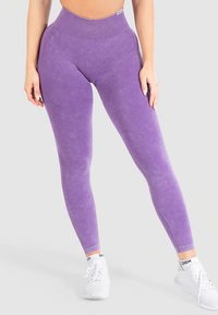 Leggings viola a vita alta realizzati in tessuto morbido e strutturato, con una vestibilità elastica e sottili dettagli a coste in vita.