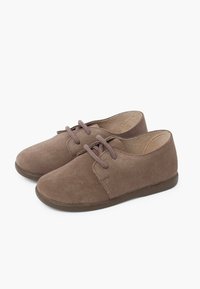 Scarpe in suede marrone con punta arrotondata, design con lacci, suola piatta in gomma e dettagli di cucitura semplici. Texture liscia e accenti minimi.