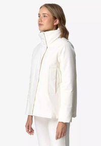 Weiße Jacke mit hohem Kragen, Frontreißverschluss und seitlicher Tasche. Glatte Textur mit strukturiertem, modernem Schnitt und minimalistischem Design.