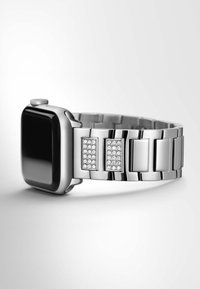 Srebrny zegarek smartwatch z prostokątną tarczą i błyszczącymi akcentami kryształowymi na pasku, posiadający projekt ogniw i gładkie wykończenie.