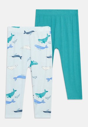 Δύο ζευγάρια παιδικά κολάν, ένα ανοιχτό γαλάζιο με πολύχρωμα σχέδια φαλαινών και ένα απλό τιρκουάζ με ραβδώσεις, απλωμένα επίπεδα σε λευκό φόντο.