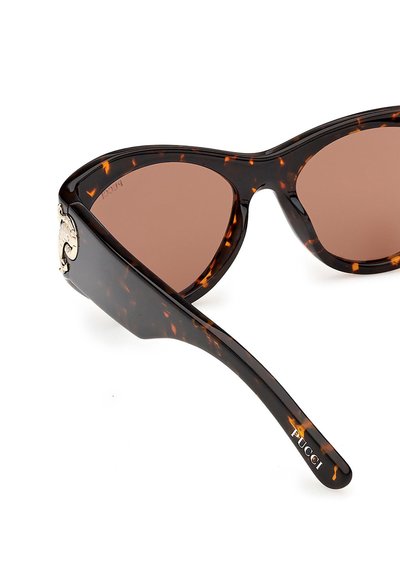 Katteøje-solbriller med skildpaddeskalleramme, brune linser og gyldent "Pucci"-logo på stangens side.