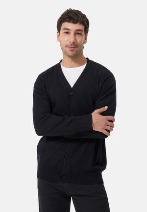 Schwarze gestrickte Strickjacke mit V-Ausschnitt, vorderen Knöpfen und gerippten Bündchen. Einfaches Design, weiche Textur, keine Muster oder Verzierungen.