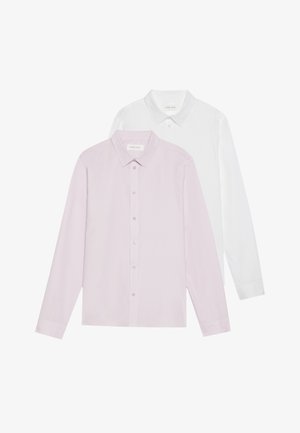 Biała koszula zapinana na guziki z długimi rękawami, zestawiona z ciemnoszarymi, szytymi na miarę spodniami i czarnymi butami, na jasnym tle.