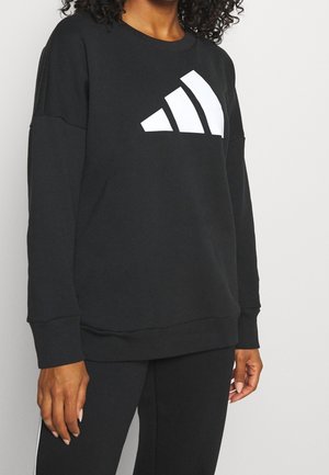 Sweatshirt noir avec un grand logo à trois rayures blanches. Il présente un col rond, des manches longues et une coupe décontractée. Texture de tissu douce.