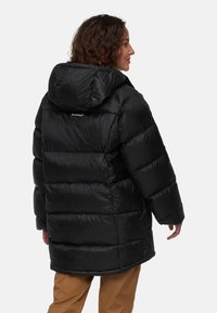 Sort pufferjakke med hætte, der har en quiltet tekstur, letvægtsmateriale og et logo på både ryggen og forsiden.