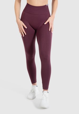 Maroon high-waisted leggings made from stretchy fabric with a smooth texture. Features side pockets and a logo on the waistband.