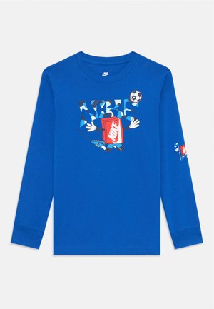 Chemise à manches longues bleue avec un design graphique comprenant un conteneur rouge, un ballon de football et un texte ludique. Fabriquée en tissu doux, coupe décontractée.