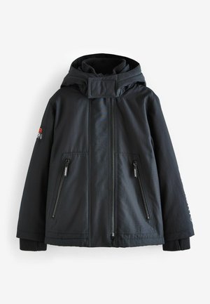 Giacca nera isolante con cappuccio, dotata di tasche frontali con zip, polsini a coste e colletto alto. Realizzata in materiale liscio e resistente.