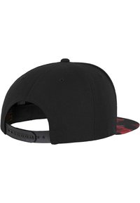 Schwarze Snapback-Cap mit flachem Schild, aus strukturiertem Stoff und mit einem rot-schwarzen gemusterten Innenfutter. Verstellbarer Kunststoffriemen auf der Rückseite.